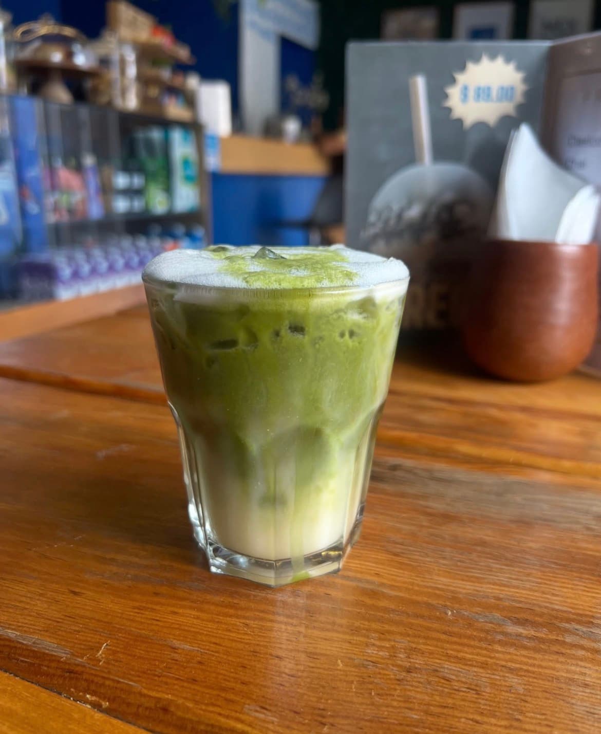 Matcha latte en vaso de cristal sobre una mesa de madera