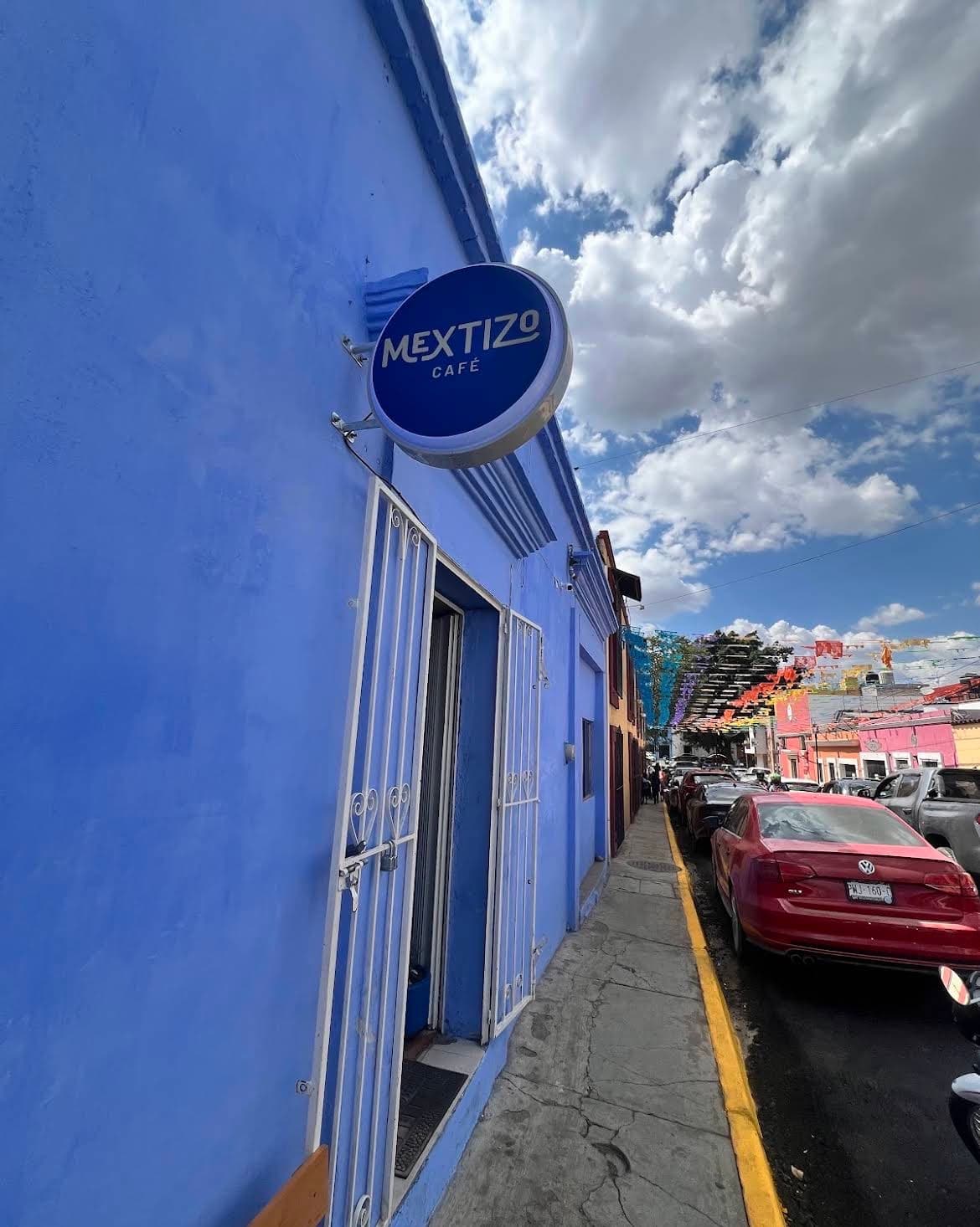 Fachada azul de Mextizo Café con su letrero circular en una calle del Centro de Oaxaca